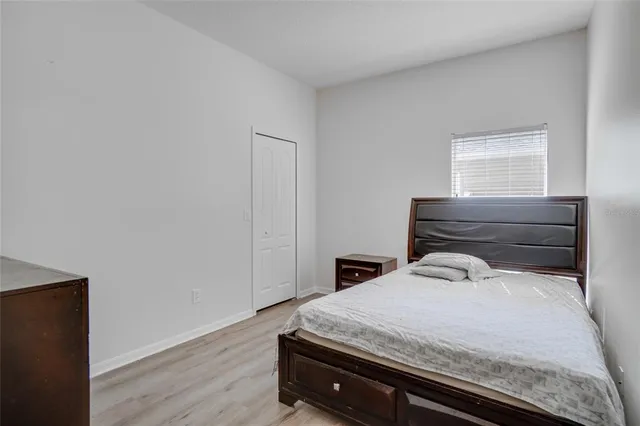 a bedroom with a bed and wooden floor