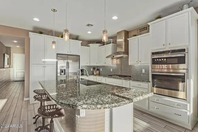 a kitchen with stainless steel appliances granite countertop a sink refrigerator and cabinets