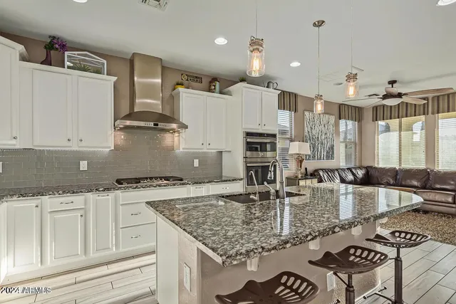 a kitchen with kitchen island granite countertop a stove and a sink