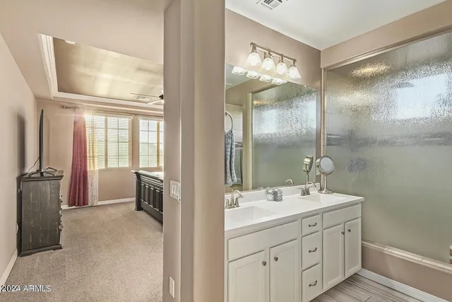 a bathroom with a double vanity sink mirror and next to a window