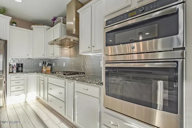 a kitchen with granite countertop white cabinets and appliances