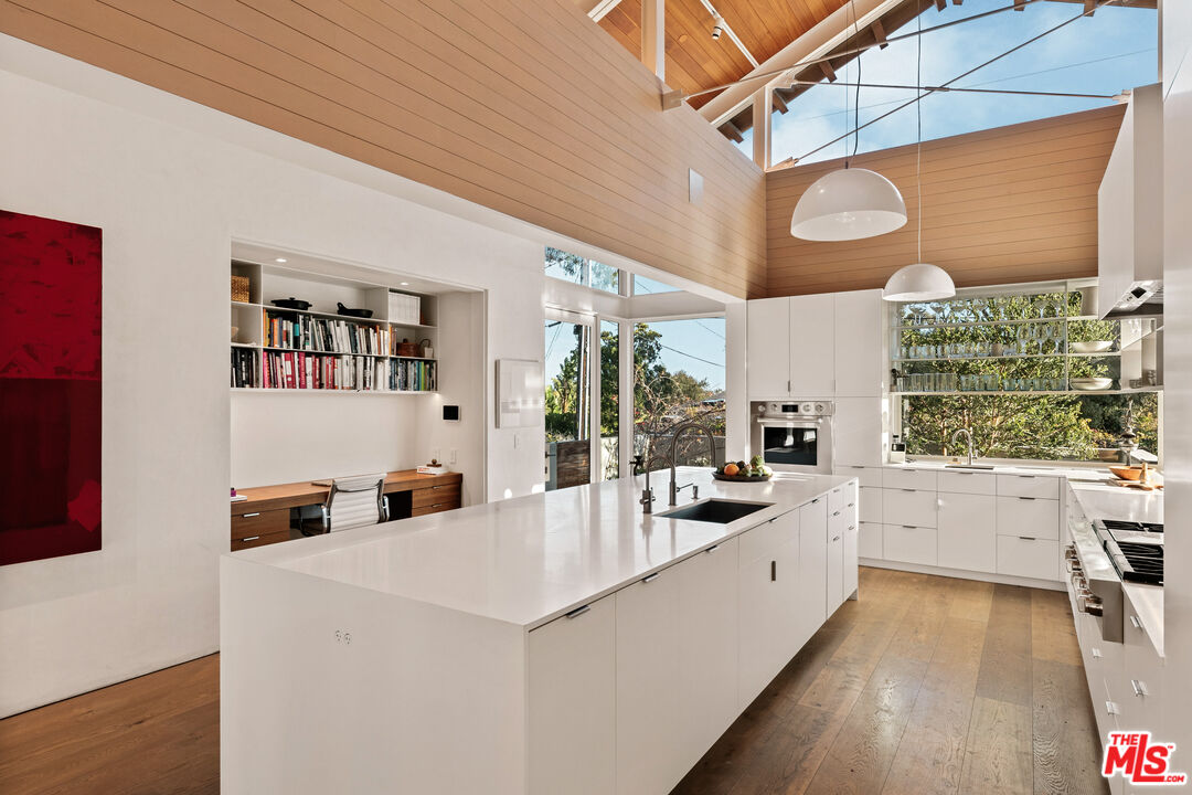 6728 Wildlife Road Malibu, CA 90265 - Photo 13 of 57 a large white kitchen with a large window and stainless steel appliances
