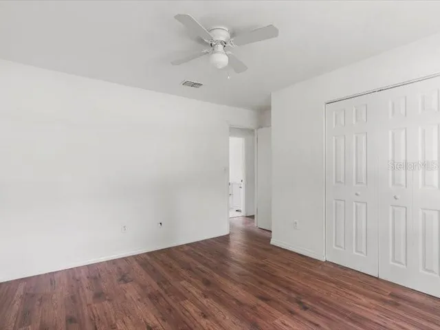 a view of an empty room with wooden floor