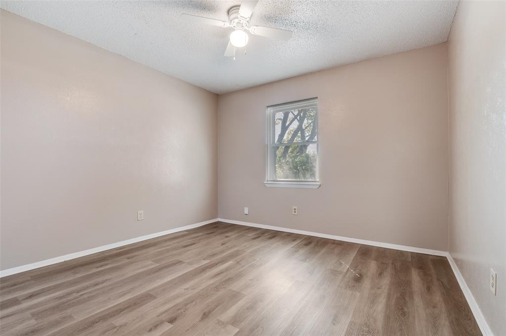 735 Middale Road Duncanville, TX 75116 - Photo 16 of 25 an empty room with wooden floor chandelier fan and windows