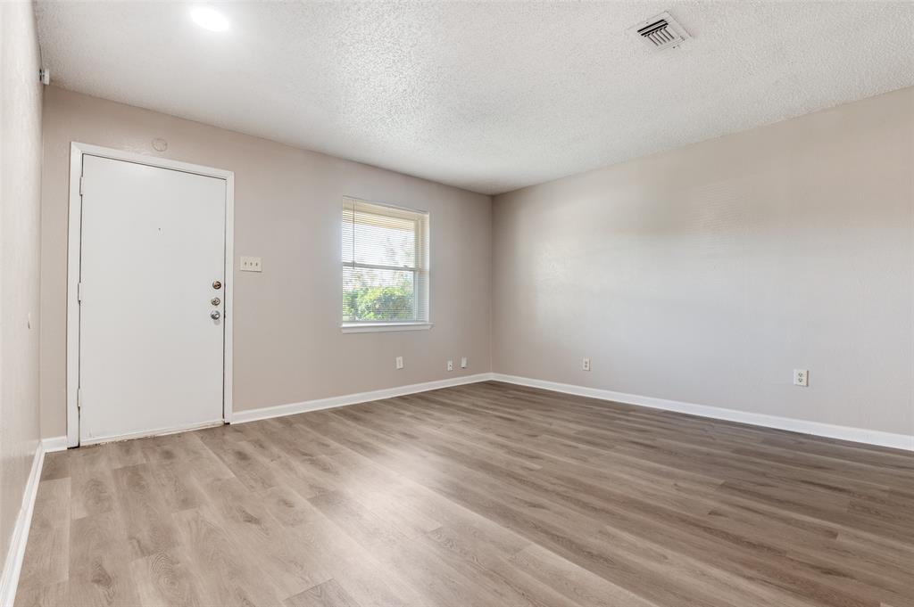 735 Middale Road Duncanville, TX 75116 - Photo 2 of 25 an empty room with wooden floor and windows