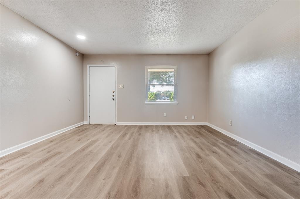 735 Middale Road Duncanville, TX 75116 - Photo 6 of 25 an empty room with wooden floor and windows