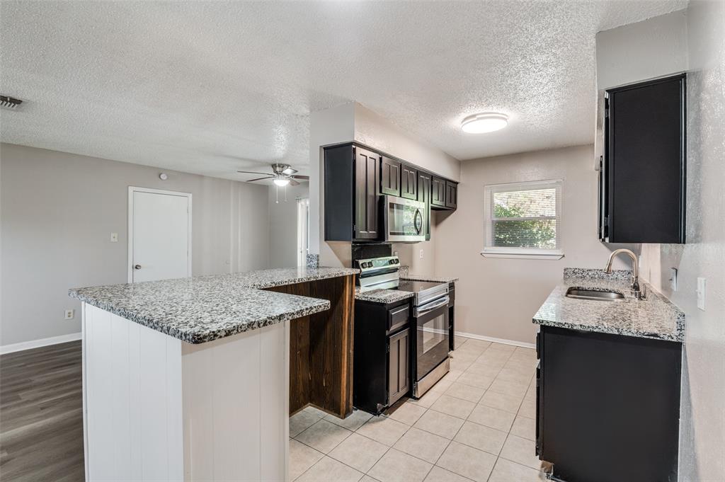 735 Middale Road Duncanville, TX 75116 - Photo 10 of 25 a kitchen with stainless steel appliances granite countertop a sink stove and refrigerator
