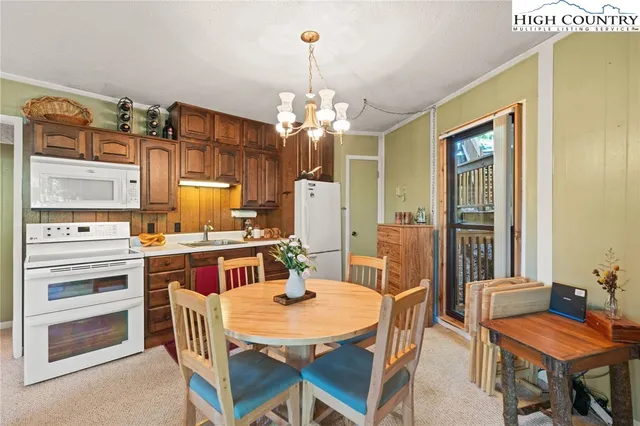 a view of a dining room with furniture a chandelier and wooden floor
