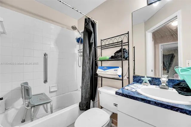 a bathroom with a sink toilet vanity and shower