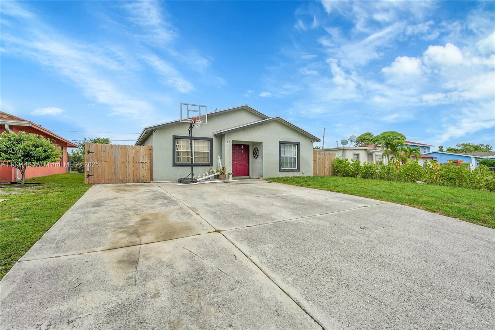 1303 West 6th Street Riviera Beach, FL 33404 - Photo 3 of 33 a front view of a house with a yard and garage