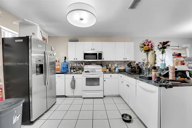 a kitchen with a sink stainless steel appliances and white cabinets