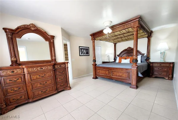 a bedroom with furniture and a mirror on dresser