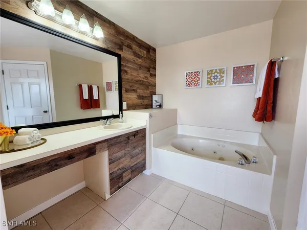 a bathroom with a tub sink and mirror