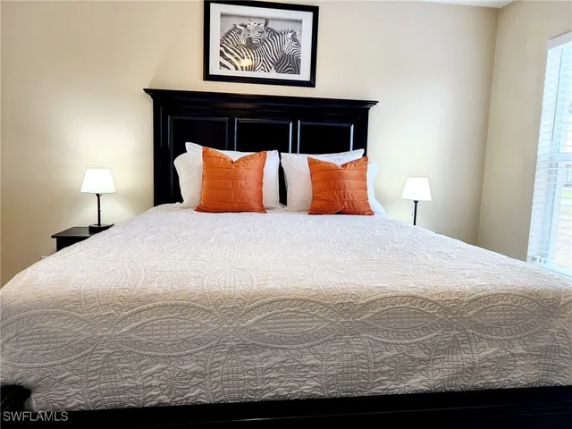 a large bed sitting in a bedroom next to a lamp