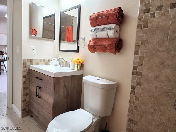 a bathroom with a toilet sink vanity and mirror