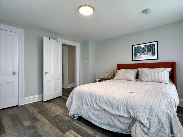 a bedroom with a bed and painting on the wall
