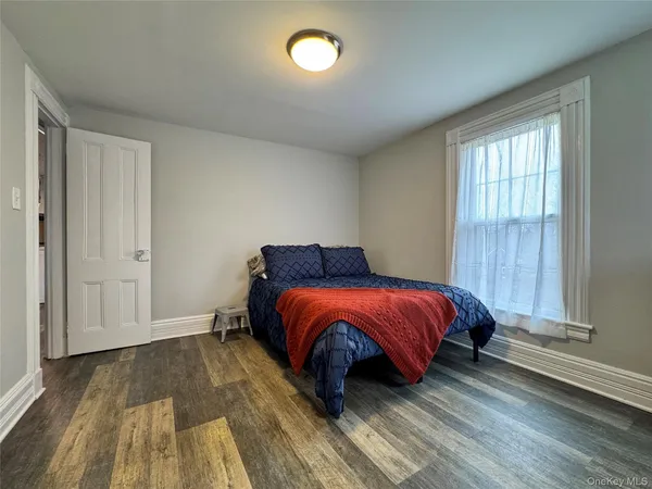 a spacious bedroom with a bed and wooden floor