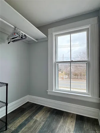 a view of a small space with wooden floor and a window