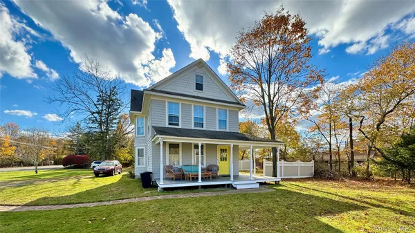 a view of a house with a yard deck and a tree
