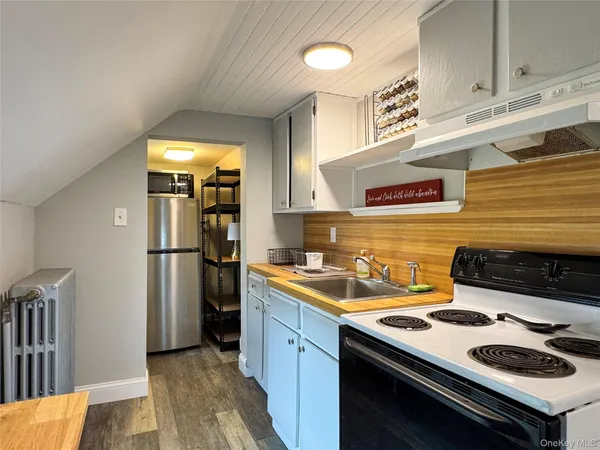 a kitchen with a sink a refrigerator and cabinets
