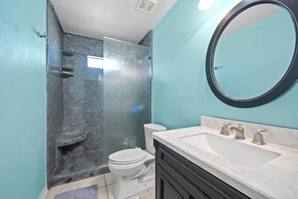 a bathroom with a sink a toilet and a mirror