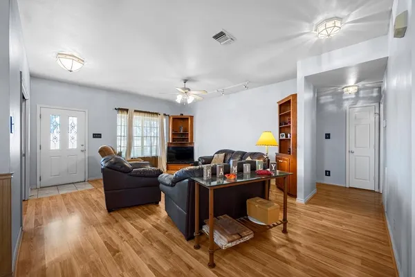 a living room with furniture and a wooden floor