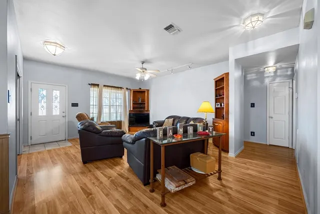a living room with furniture and a wooden floor