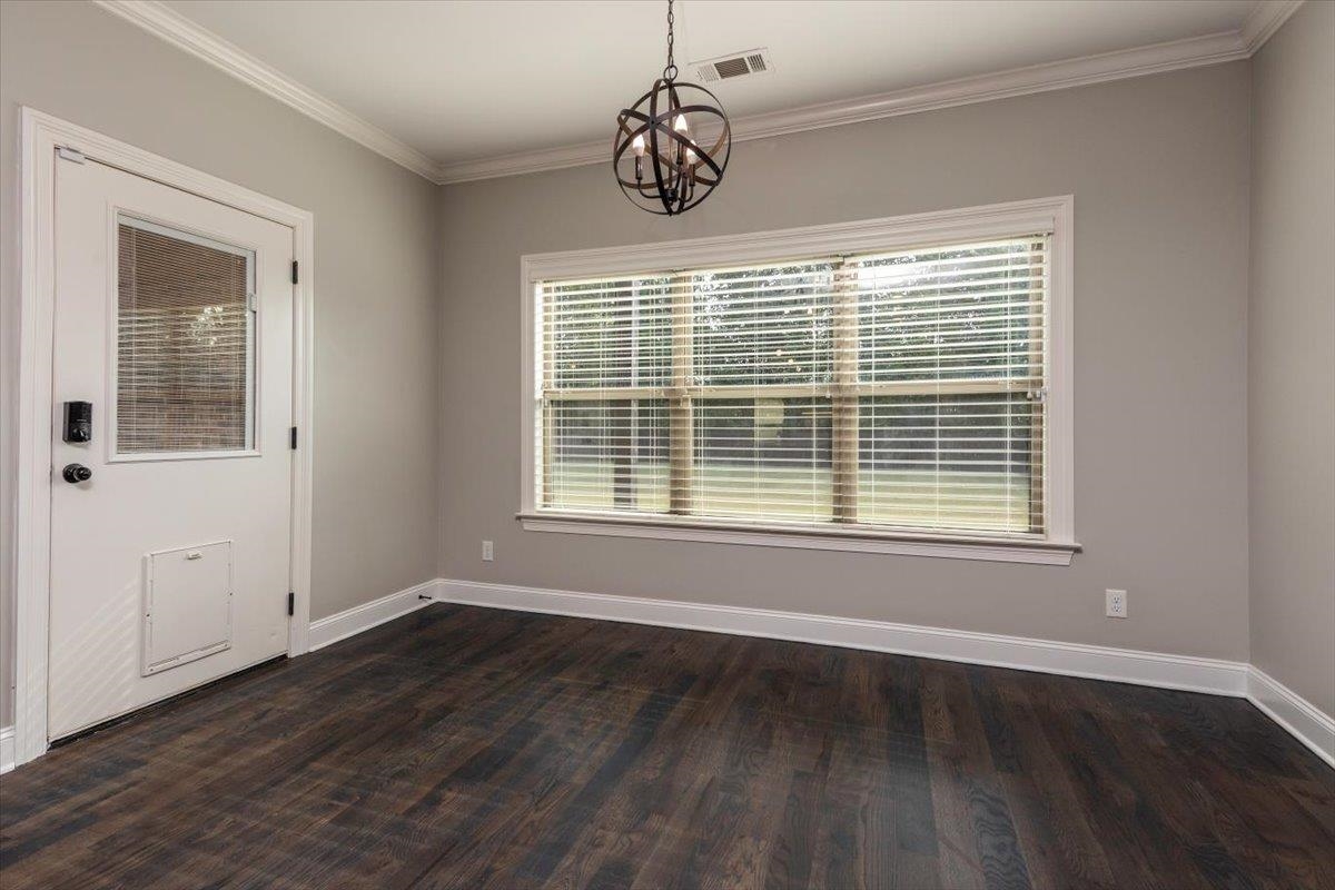 3328 Straw Bridge Road Olive Branch, MS 38654 - Photo 17 of 28 Wood-finish flooring, crown molding, white trim, and a contemporary spherical chandelier