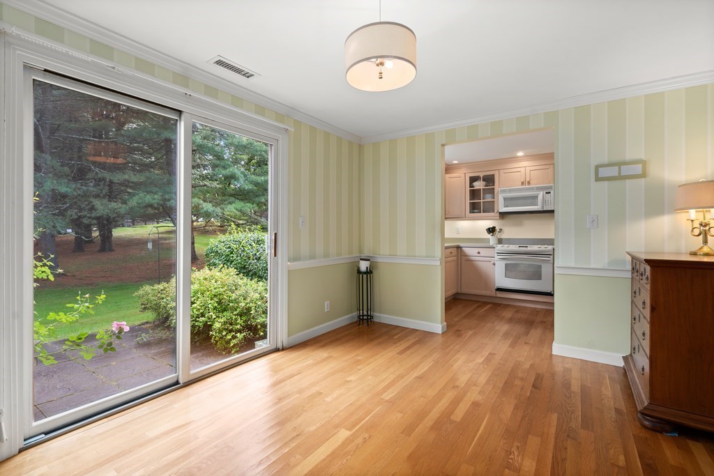 12 Jericho Road, Unit 12 Weston, MA 02493 - Photo 7 of 14 a kitchen with white cabinets and wooden floor