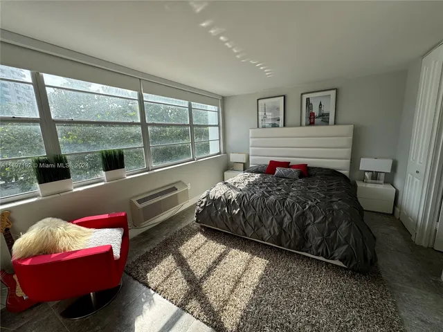 a bedroom with a bed and a large window