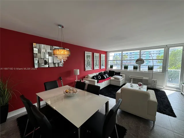 a living room with furniture a large window and a dining table