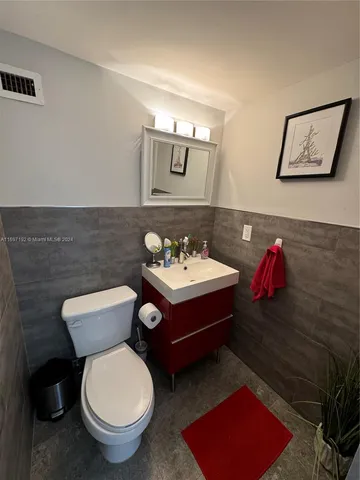 a bathroom with a toilet sink and mirror