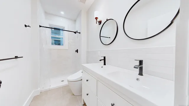 a bathroom with a sink a toilet and a mirror