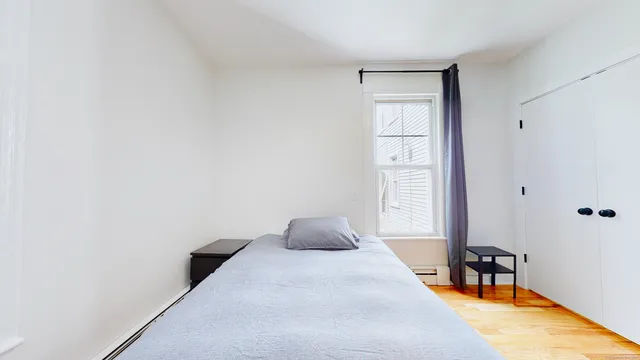 a bedroom with a bed and a window