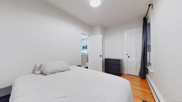 a bedroom with a bed and wooden floor