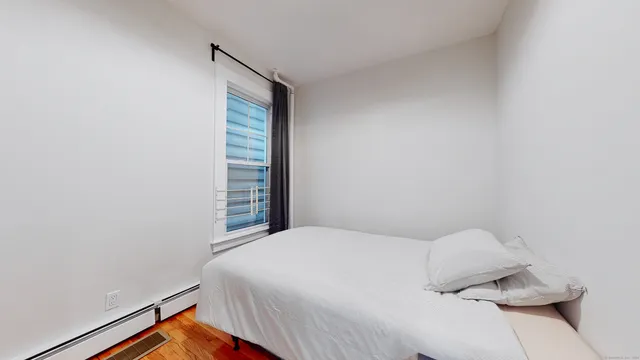 a bedroom with a bed and a window