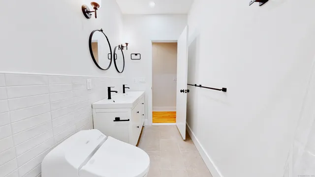 a bathroom with a sink a toilet and a mirror