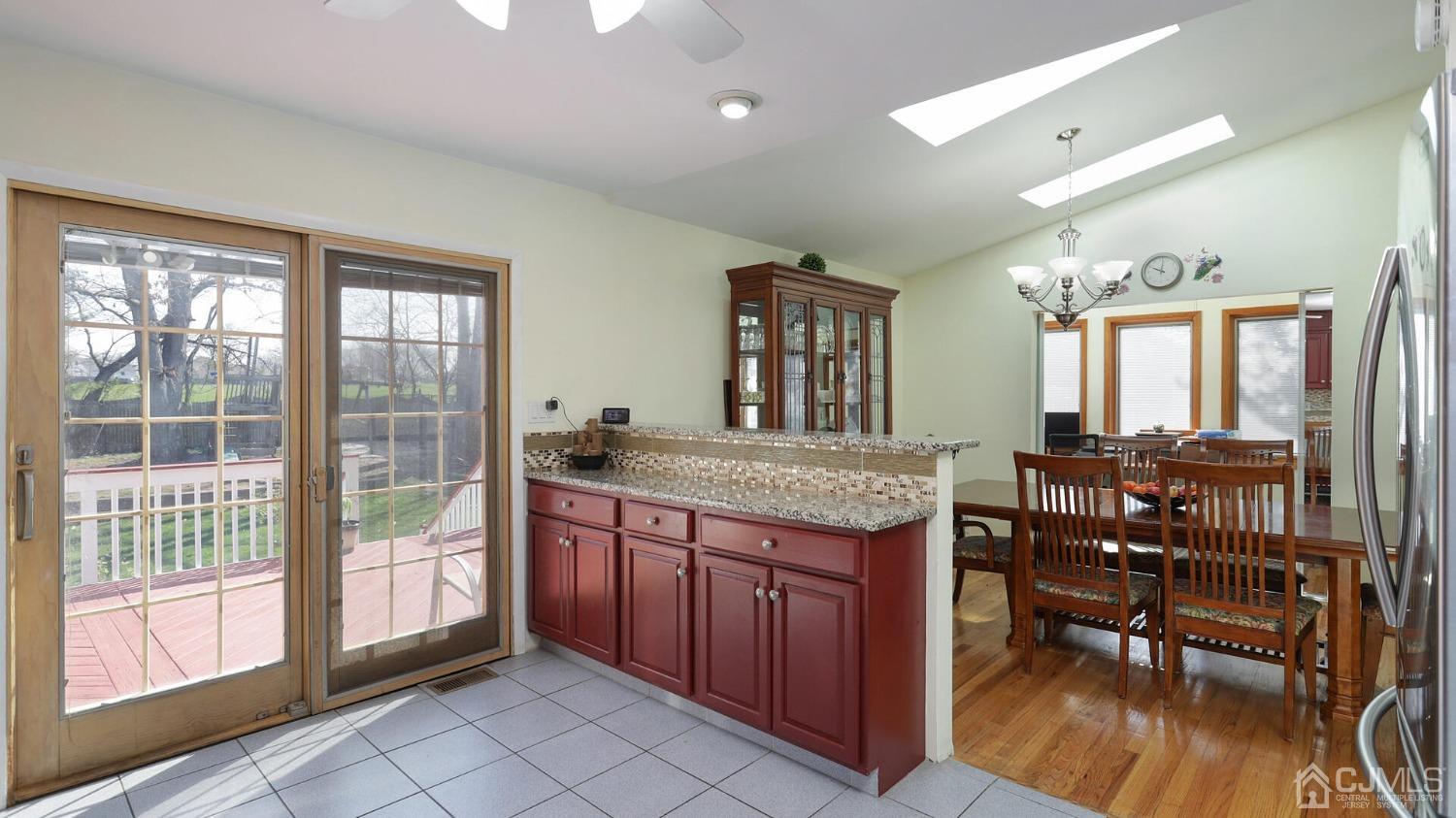 20 Peake Road Edison, NJ 08837 - Photo 13 of 34 a open kitchen with granite countertop a stove a sink a dining table and chairs