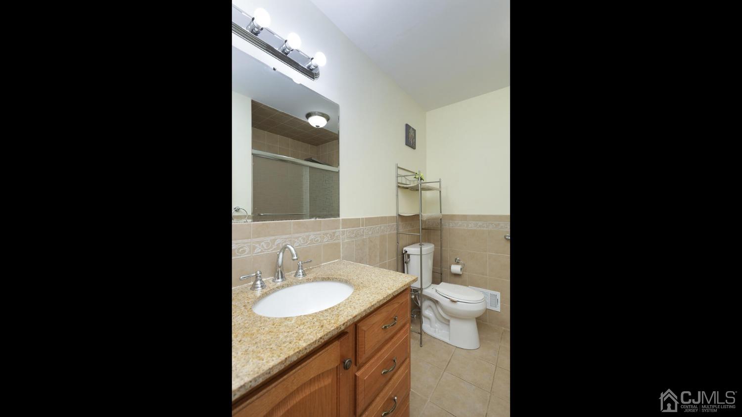20 Peake Road Edison, NJ 08837 - Photo 21 of 34 a bathroom with a granite countertop sink toilet and a mirror