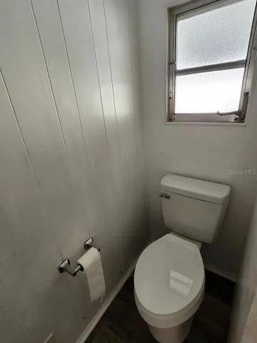 a white toilet sitting next to a window