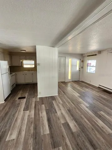 a view of empty room with wooden floor and window