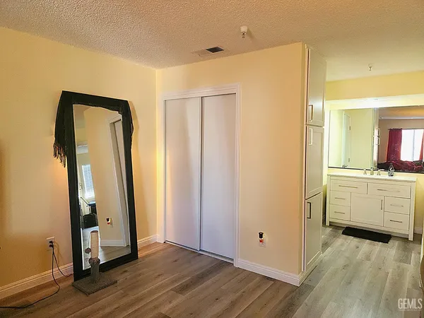a view of a hallway with bathroom and wooden floor