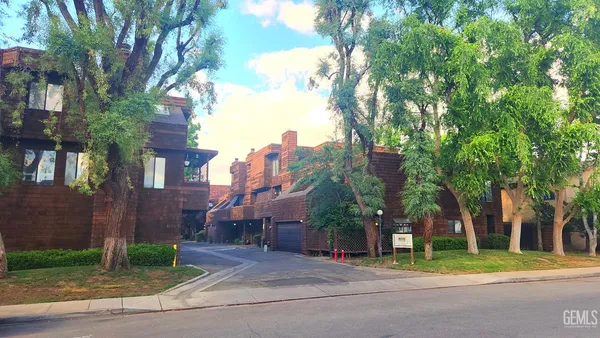 a front view of a house with a yard and trees
