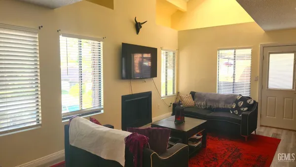a living room with furniture a flat screen tv and a window