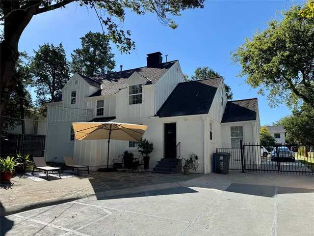 a view of a house with backyard and sitting area