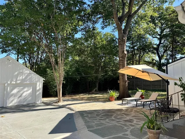a view of a backyard with chair potted plants