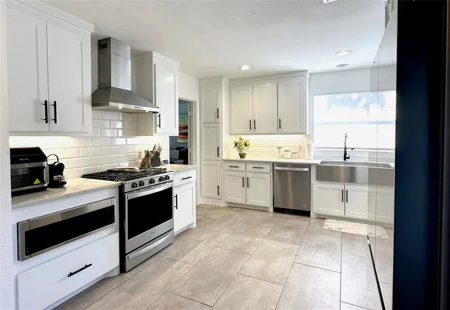 a kitchen with stainless steel appliances granite countertop a stove and a sink