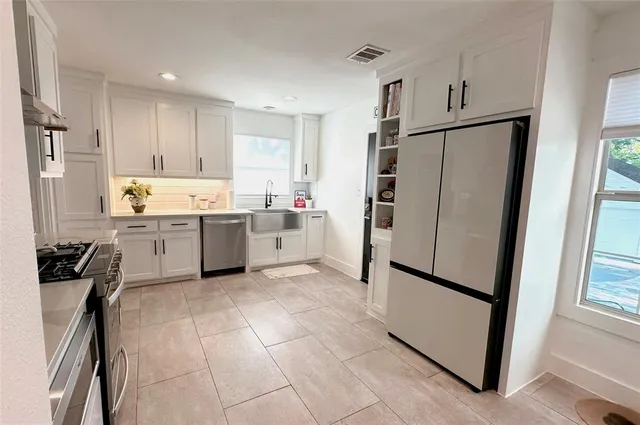 a kitchen with stainless steel appliances a refrigerator sink and cabinets