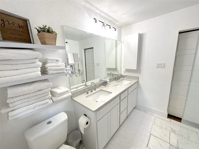 a bathroom with a sink a toilet and shower