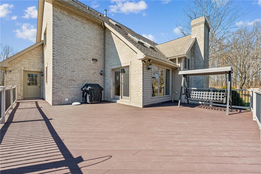 404 Oneida Trail Mercer, PA 16137 - Photo 35 of 50 Large composite deck, with motion detection light, walkway to the basement garage, steps to the yard, porch swing & gas grill.